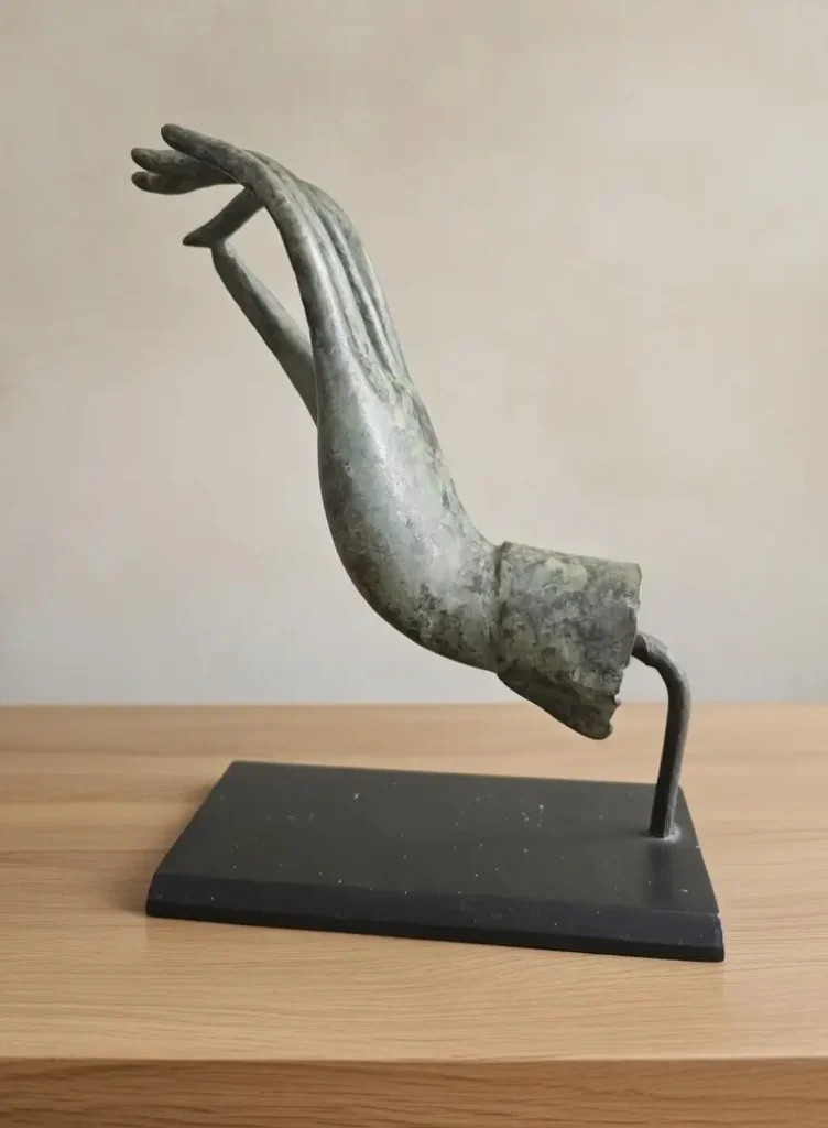 Statuette main en bronze patiné, sculpture ancienne montée sur socle noir. Objet de décoration vintage ou artistique.